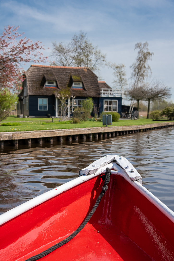 Percorrendo un canale di Giethoorn, in Olanda, a bordo di una barca elettrica rossa