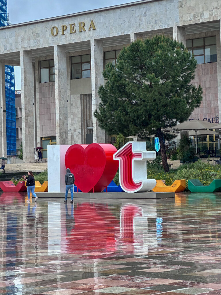 piazza skenderbej a Tirana in un giorno di pioggia con la scritta i love Tirana