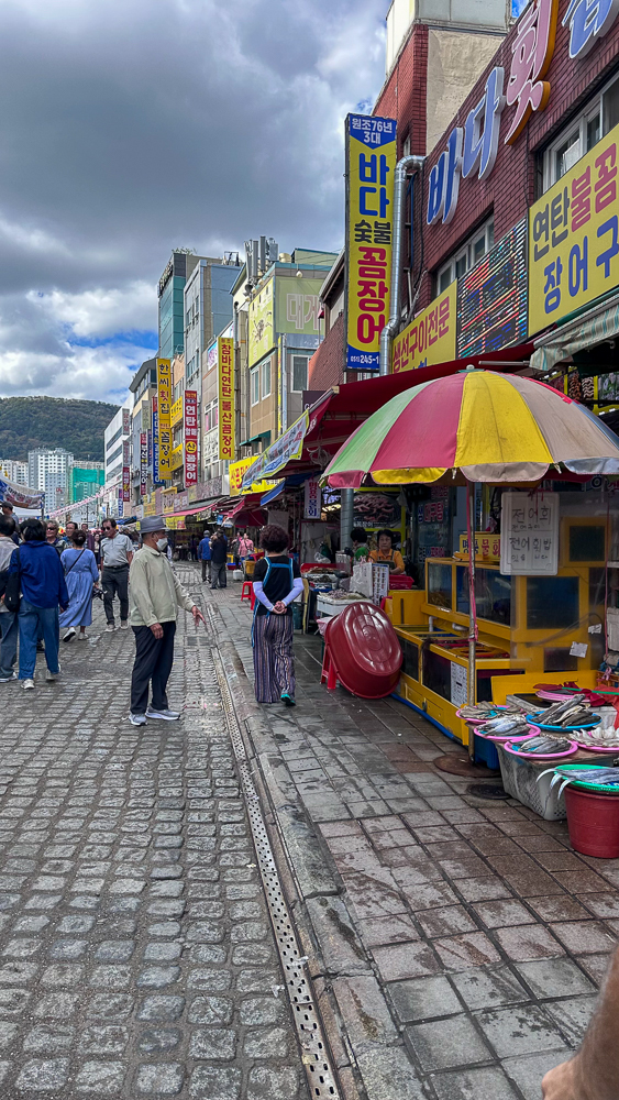 Busan, Jagalchi market, bancarelle con pesce fresco, ombrelloni colorati e tante scritte giganti